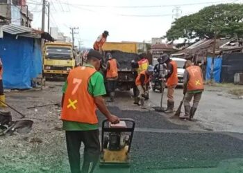 Pekerja dari BPJN Aceh sedang melakukan pengaspalan dan penambalan jalan berlubang di depan SPBU Labuhanhaji Barat.