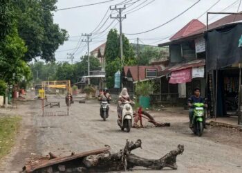 Warga Kecamatan Meukek, Kabupaten Aceh Selatan memasang palang kayu di jalan nasional sebagai bentuk protes atas proyek jalan yang berdebu.